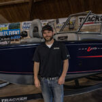 Dane next to one of the boats at the Allstar Marine set up